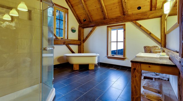 Bathroom with refinished claw foot tub and barn board trim in a home converted