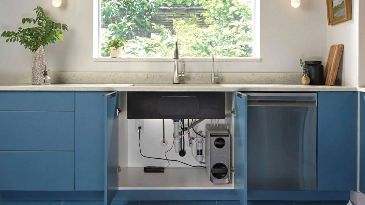 A multi-stage under-counter water filtration system installed neatly inside a ki