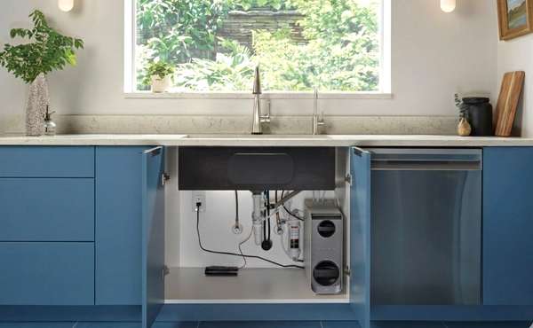 A multi-stage under-counter water filtration system installed neatly inside a ki