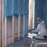 Closed cell spray foam insulation being applied to basement walls