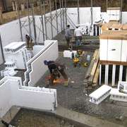 Workers assemble ICF blocks to pour a basement foundation