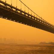 A hazy New York, New York, skyline & bridge colored by orange wildfire smoke