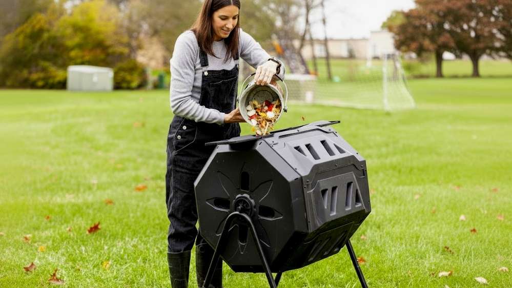 dropping food scraps in to a backyard compost tumbler
