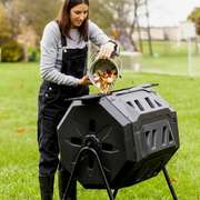 dropping food scraps in to a backyard compost tumbler