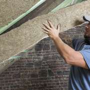 A worker installs natural non toxic insulation batt made from grass