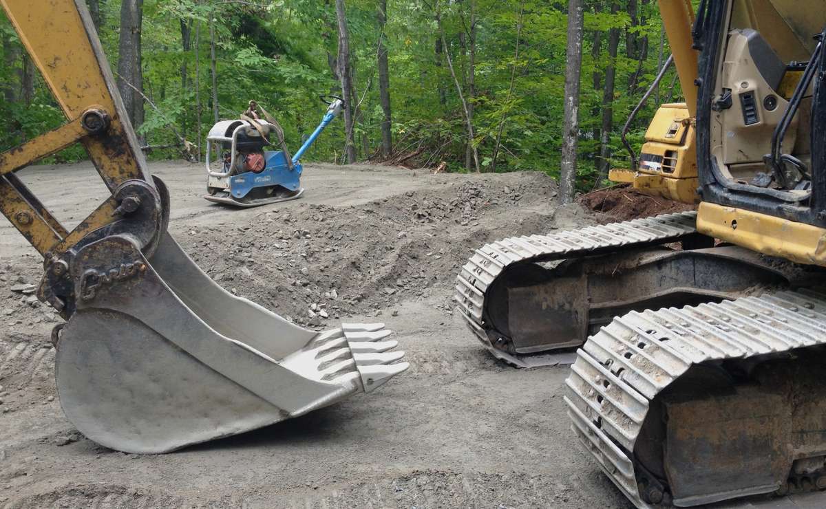 Digging the gravel by excavator for the foundation for a green home build