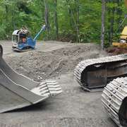Digging the gravel by excavator for the foundation for a green home build