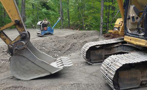 Digging the gravel by excavator for the foundation for a green home build