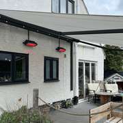 Retractable awnings extended over large windows on a house