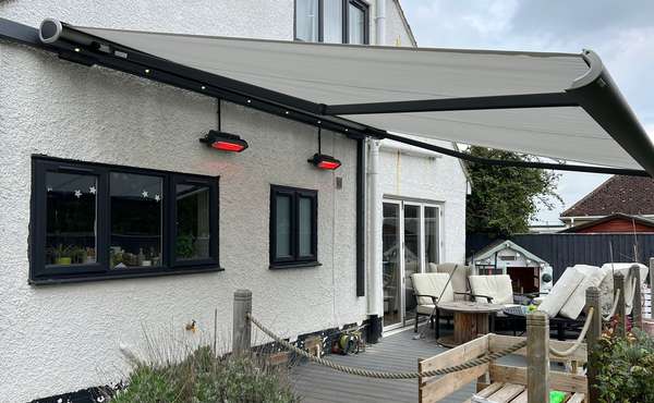 Retractable awnings extended over large windows on a house