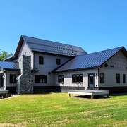 A beautiful standing seam metal roof on a modern home in a natural setting.