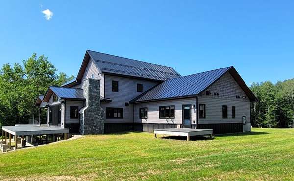 A beautiful standing seam metal roof on a modern home in a natural setting.