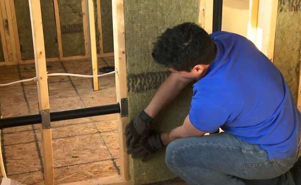 Installing soundproofing batts in interior partition walls of drywall