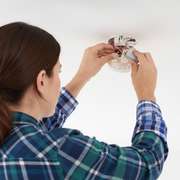 A woman connecting the battery of a carbon monoxide detector