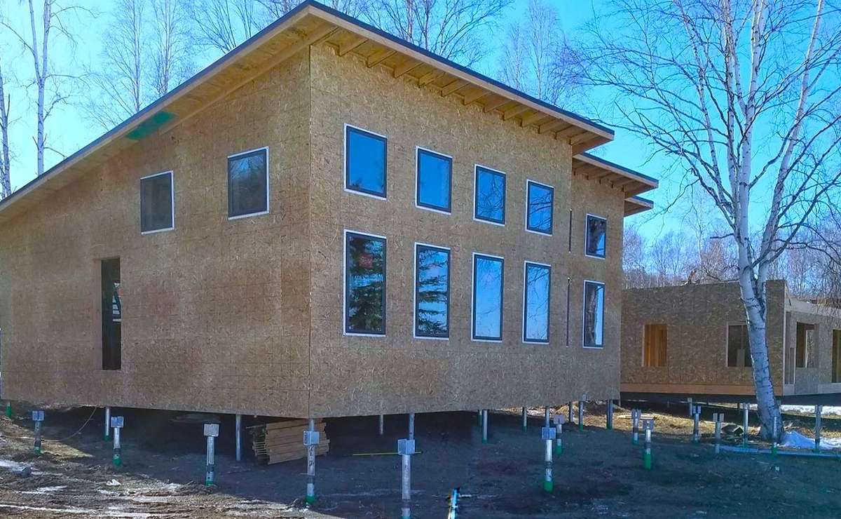 A modern prefab home module sat on a helical pile foundation.