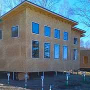 A modern prefab home module sat on a helical pile foundation.