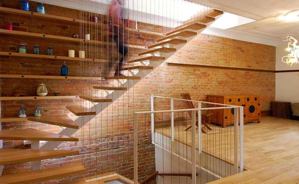 A modern, minimalist staircase with wood treads Image © Studio MMA Architects