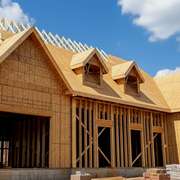 A home under construction with wood framing completed and sheating on the roof