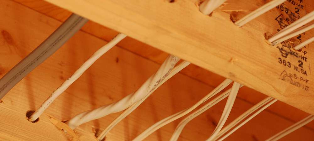 Passage de fils à travers des solives de plancher en bois massif
