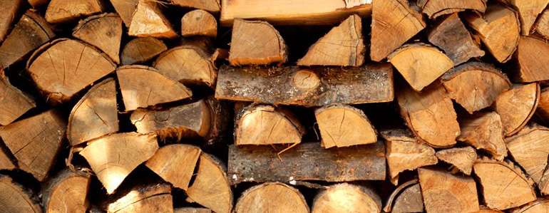 Bois de chauffage empilé prêt pour un bon feu chaud à la maison © Ecohome