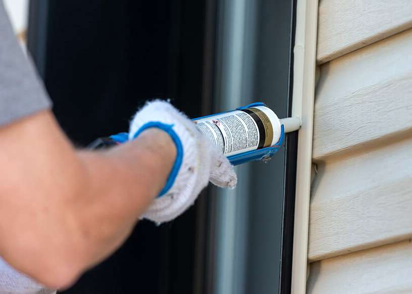 Application de calfeutrant extérieur lors d'une installation de fenêtre étanche