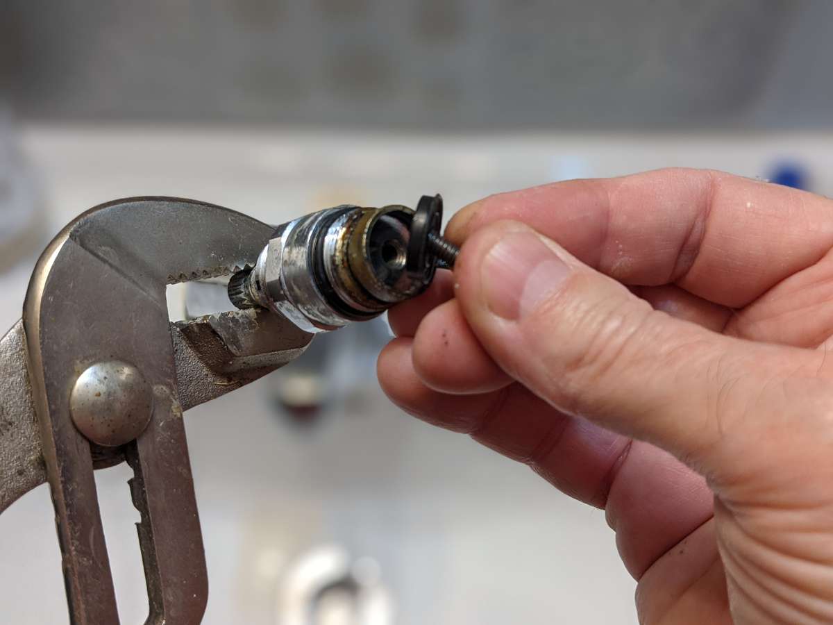 Flick the washer out of the faucet cartridge with the screw as you remove it