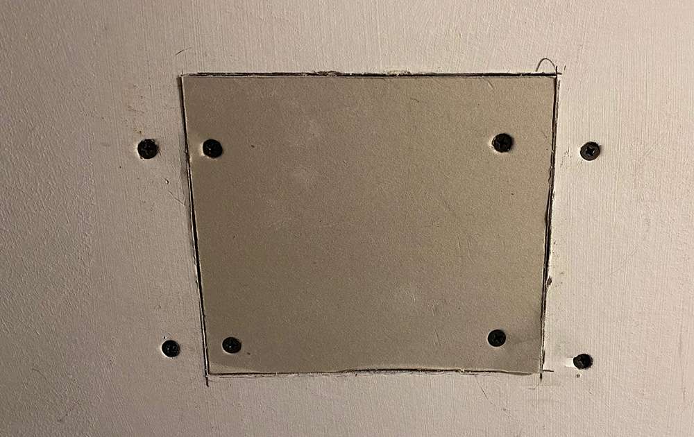 install the new piece of drywall and screw it to the wood backing.