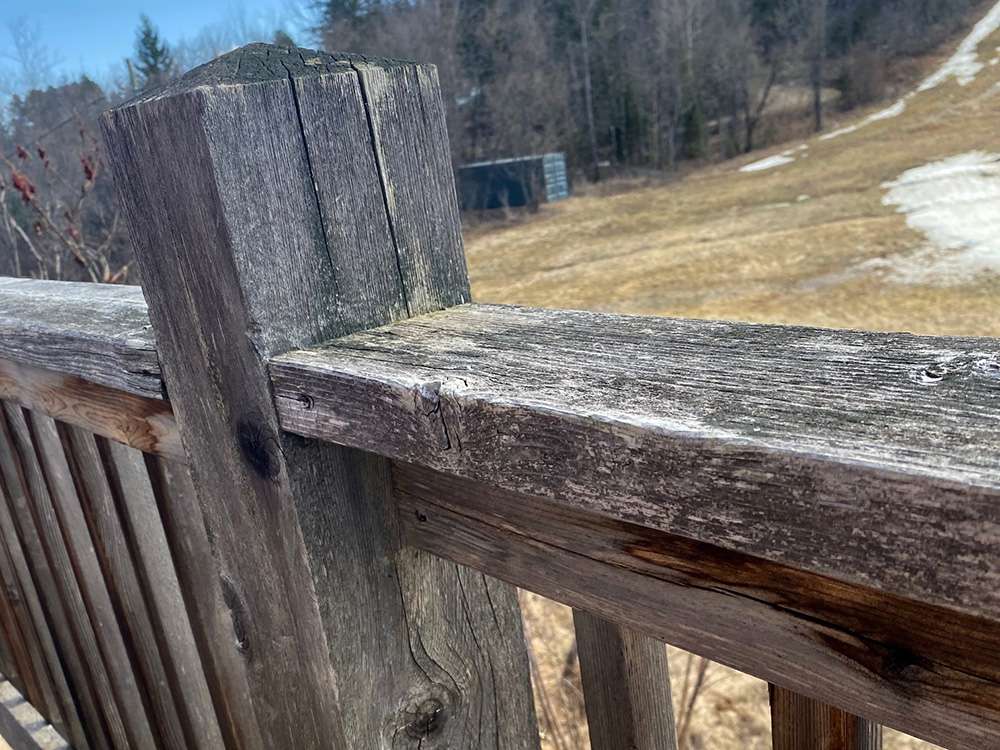 Staining a cedar deck to look like new - Before photo of the deck railing