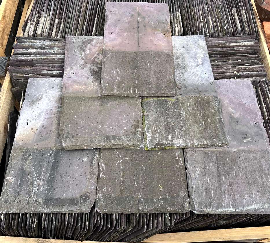 Une palette empilée haut avec des ardoises naturelles soigneusement retirées et récupérées, prêtes à être revendues.