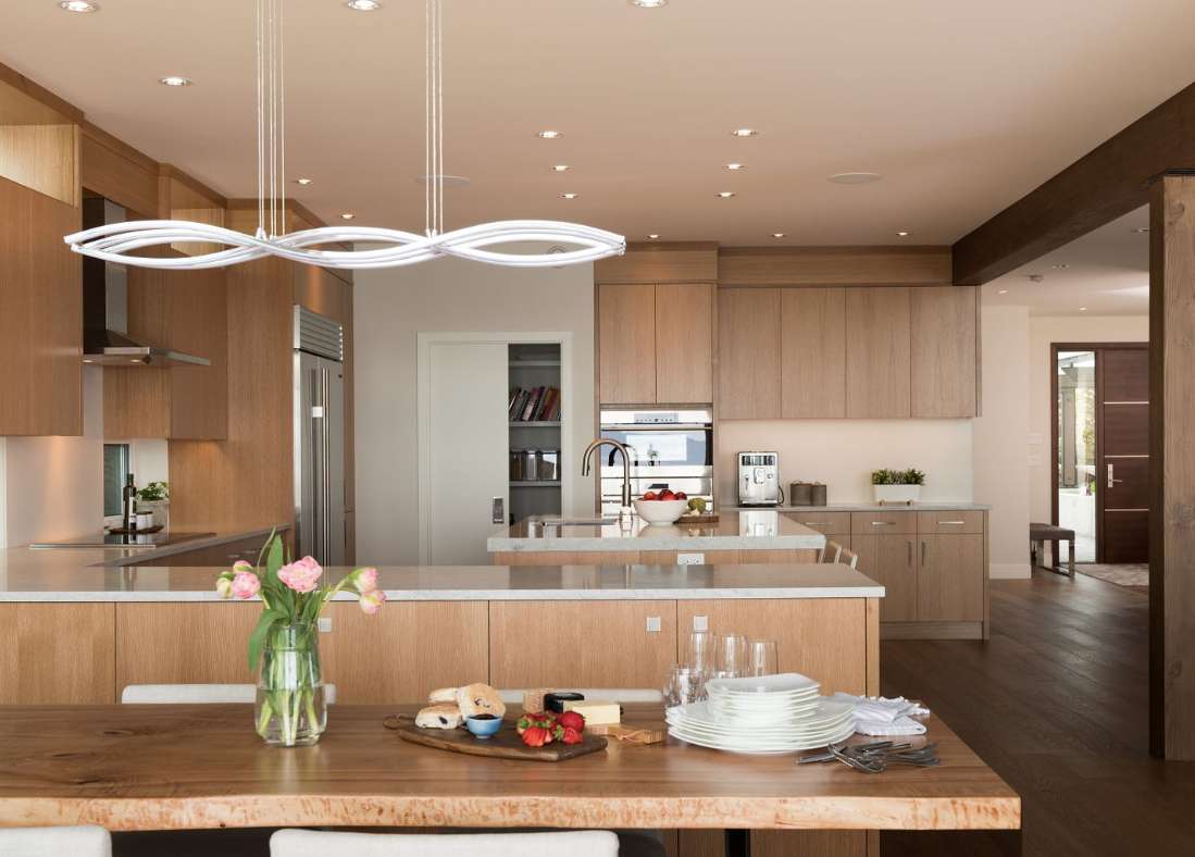 Custom rift-cut white-oak cabinetry and local stone detailing in the kitchen of the award-winning Net Zero Home by Falcon Heights Contracting.