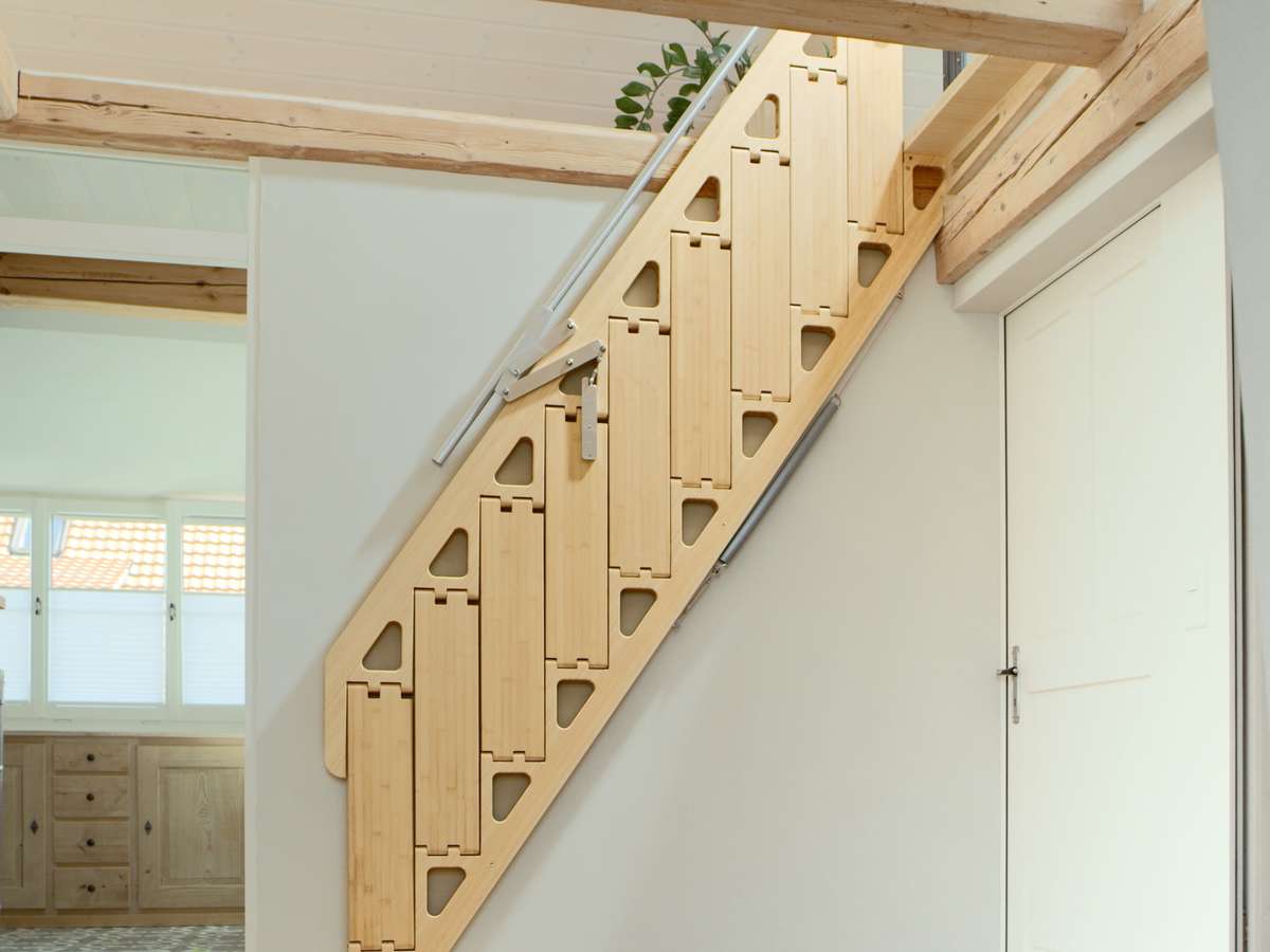 A folding staircase tucks up against a wall to save space