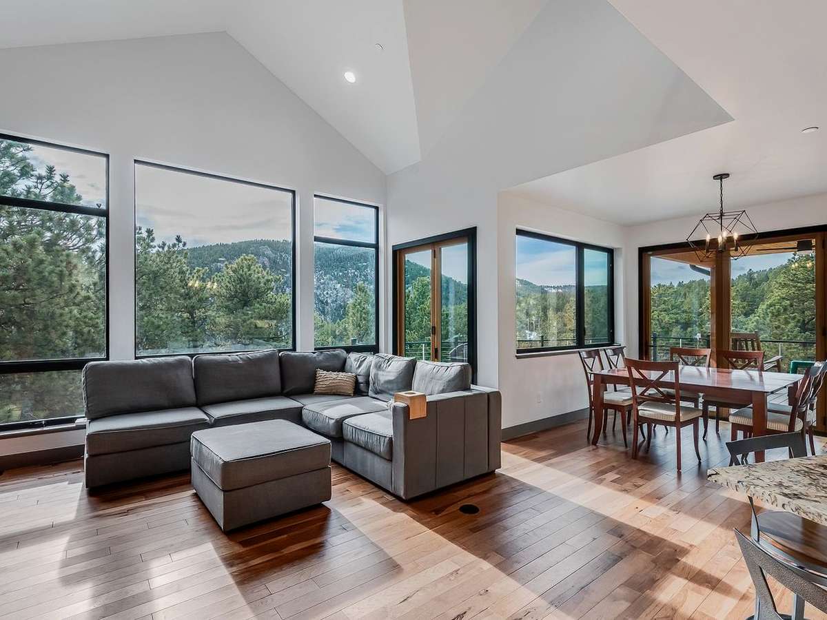 Open concept great room with high ceilings and large windows