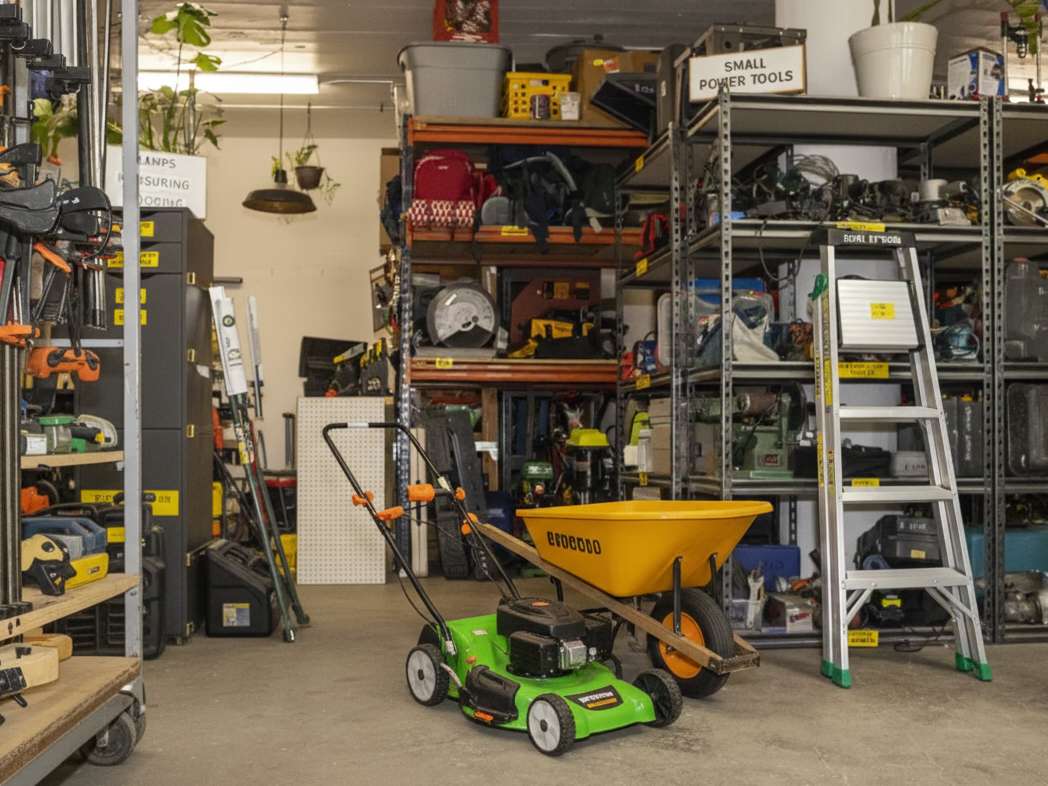A well-organized communal tool library in a workshop setting with various hand and power tools