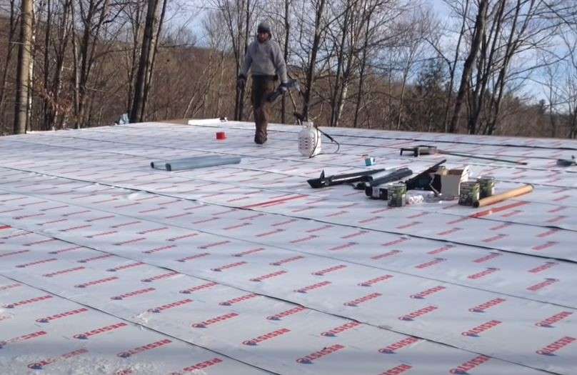 Travailleur préparant un toit vert sur une maison