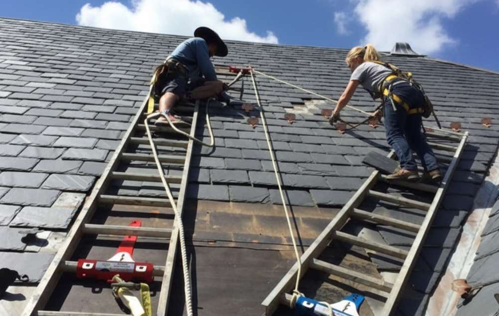 Workers on Ladder Jacks repairing a roof