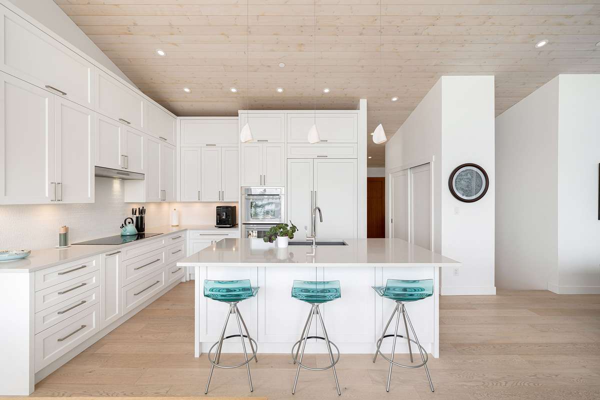 A luxury kitchen with white cabinets and an induction cooktop.